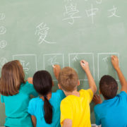 students writing characters on a board